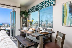 comedor con mesa, sillas y ventana en Ocean View 3 Bedrooms Condo, just steps from the park, pier & water! en Imperial Beach