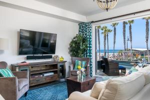 uma sala de estar com uma televisão de ecrã plano e uma sala de estar em Ocean View 3 Bedrooms Condo, just steps from the park, pier & water! em Imperial Beach