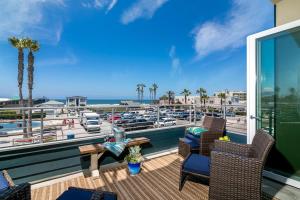 a balcony with chairs and a view of a marina at Ocean View 3 Bedrooms Condo, just steps from the park, pier & water! in Imperial Beach