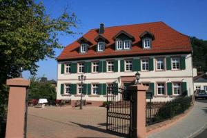 un grand bâtiment vert et blanc avec un toit rouge dans l'établissement Hotel Restaurant Ölmühle, à Landstuhl