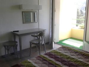 a bedroom with a bed and a table and chairs at Hotel Saint Jacques in Vals-les-Bains