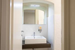リオマッジョーレにあるJ&Kのバスルーム(白い洗面台、鏡付)