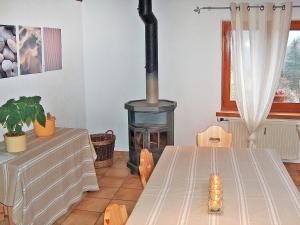 comedor con estufa de leña en una habitación en Apartment Les Galets by Interhome en Ocourt