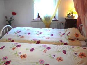 Un dormitorio con una cama con flores. en Apartment Le Ruisseau by Interhome, en Ocourt