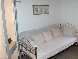 a couch with white pillows in a room at Apartment Les Galets by Interhome in Ocourt