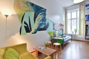 柏林的住宿－柏林城藝術旅舍，客厅配有沙发和墙上的绘画