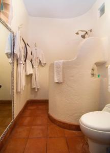 a bathroom with a toilet and towels hanging on the wall at Porton del Cielo in Pátzcuaro