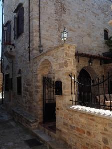 a stone building with a gate and a lamp on it at Traditional Tower in the center of kalamoti in Chios