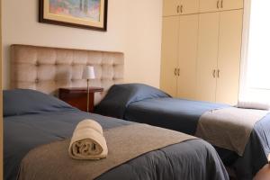 a bedroom with two beds and a towel on the bed at Cayma’s Apart in Arequipa