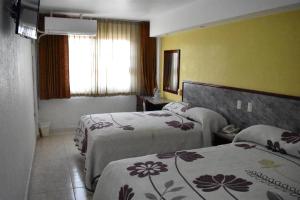 a hotel room with two beds and a window at Hotel Baluarte in Veracruz