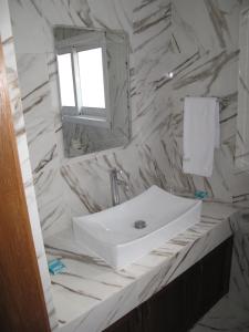 y baño con lavabo blanco y espejo. en Platinum Suites, en Kakopetria