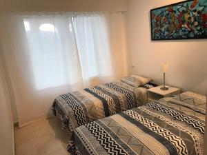 pokój z dwoma łóżkami i obrazem na ścianie w obiekcie Marbella - Estepona beach frontline apartment w mieście Estepona