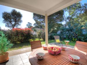a wooden table with a bowl of fruit on a porch at Holiday Home La Plage by Interhome in Labenne