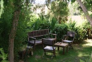 due sedie e una panca di legno in giardino di Casas Rurales Los Cortijos ad Alcaraz