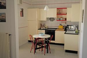 una pequeña cocina con mesa y sillas. en GH36 en Marina di Ragusa