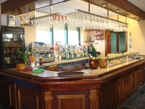 a bar with a wooden counter with a lot of alcohol at Hotel Brisamar in Bañugues