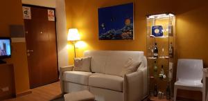 a living room with a white couch and a television at Sky-Inn in La Spezia