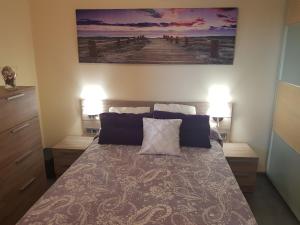 a bedroom with a bed with two lamps and a painting on the wall at Vista al mar playa del aguila! in San Bartolomé