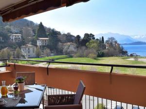 a balcony with a table and chairs and a view of the water at Apartment La Perla di Laveno by Interhome in Laveno-Mombello