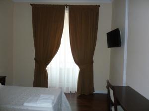 マドリードにあるオスタル マヨールのベッドルーム1室(ベッド1台付)、窓(カーテン付)