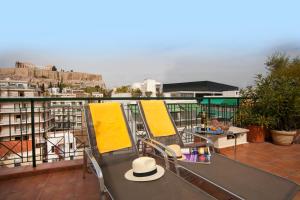a balcony with chairs and tables on a roof at Philippos Hotel in Athens