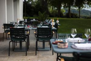 eine Gruppe von Tischen und Stühlen mit Weingläsern in der Unterkunft L'Auberge Basque-Relais & Châteaux in Saint-Pée-sur-Nivelle
