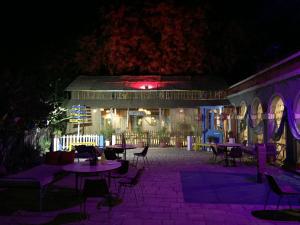 a patio with tables and chairs at night at Hotel Grand Barrack in Khandwa