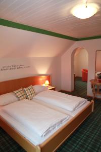 ein Schlafzimmer mit einem großen Bett in einem Zimmer in der Unterkunft Gasthof Karlwirt in Sankt Andrä im Lungau