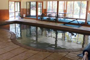 una piscina con mesa y sillas. en Bells Estate Great Ocean Road Cottages en Torquay