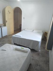 Habitación con 2 camas y puerta. en Hotel Raiz, en Manaus
