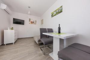 ein Wohnzimmer mit einem weißen Tisch und Stühlen in der Unterkunft Apartman Ankica in Kaštela