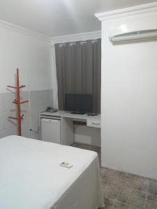 a bedroom with a bed and a desk with a computer at Hotel Raiz in Manaus