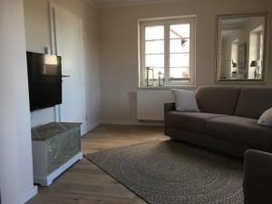 a living room with a couch and a flat screen tv at Christmann's Cottage in Weisenheim am Berg