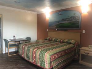 Habitación de hotel con cama y mesa en Robinhood Motel en Anaheim