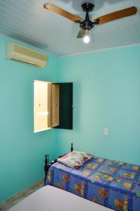 Schlafzimmer mit einem Deckenventilator und einem Bett in der Unterkunft Casas Da Vó Maria in Olímpia