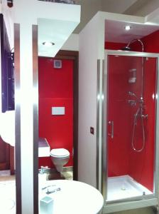 y baño rojo con aseo y ducha. en Donna Franca, en Lecce