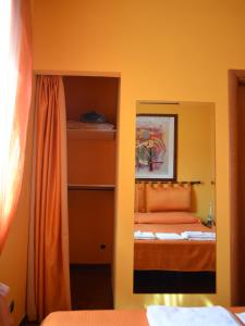 a bedroom with an orange bed and a mirror at Il Giardino di Venere in Terni