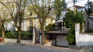 a white house with a gate and a garage at Resident hill resort in Belgrade