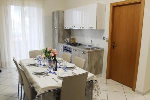 a dining room with a table with chairs and a kitchen at Casa, Mare-Etna-Taormina in Fondachello