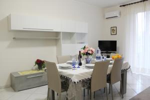 a dining room with a table and chairs with flowers on it at Casa, Mare-Etna-Taormina in Fondachello