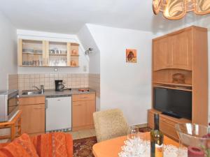 バート・エルスターにあるStunning apartment with terrace in Saxonyのキッチン(木製キャビネット、ワイン1本付きのテーブル付)