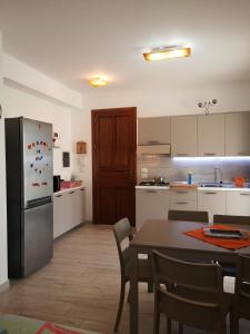 a kitchen with a table and a refrigerator at Casa Frida in San Vito lo Capo