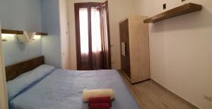 a small bedroom with a bed and a door at Casa Frida in San Vito lo Capo