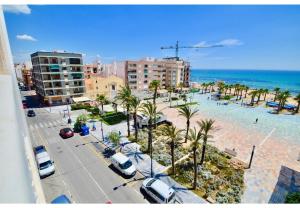 an aerial view of a beach with palm trees and cars at 12 Sunny Sea Views in La Mata