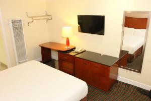 Una habitación de hotel con una cama y un escritorio con televisión. en Town and Country Inn, en Santa Maria