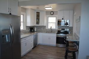 a kitchen with white cabinets and a black refrigerator at Stafford Lake House in McHenry