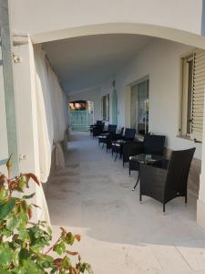 - une rangée de tables et de chaises sur la terrasse dans l'établissement Villa Alberta Hotel, à Pula