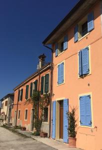 una fila di case con persiane blu di Le Querce Apartments a Ronchi