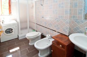 uma casa de banho com um WC, um lavatório e uma máquina de lavar roupa em Shaka guest house em Giba