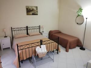 a bedroom with two beds and a table and a mirror at B&B Quasimodo in Caltagirone